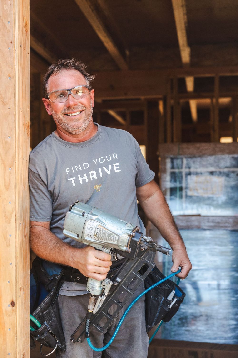 Workers using power tools during a construction project in a wooden framed structure.