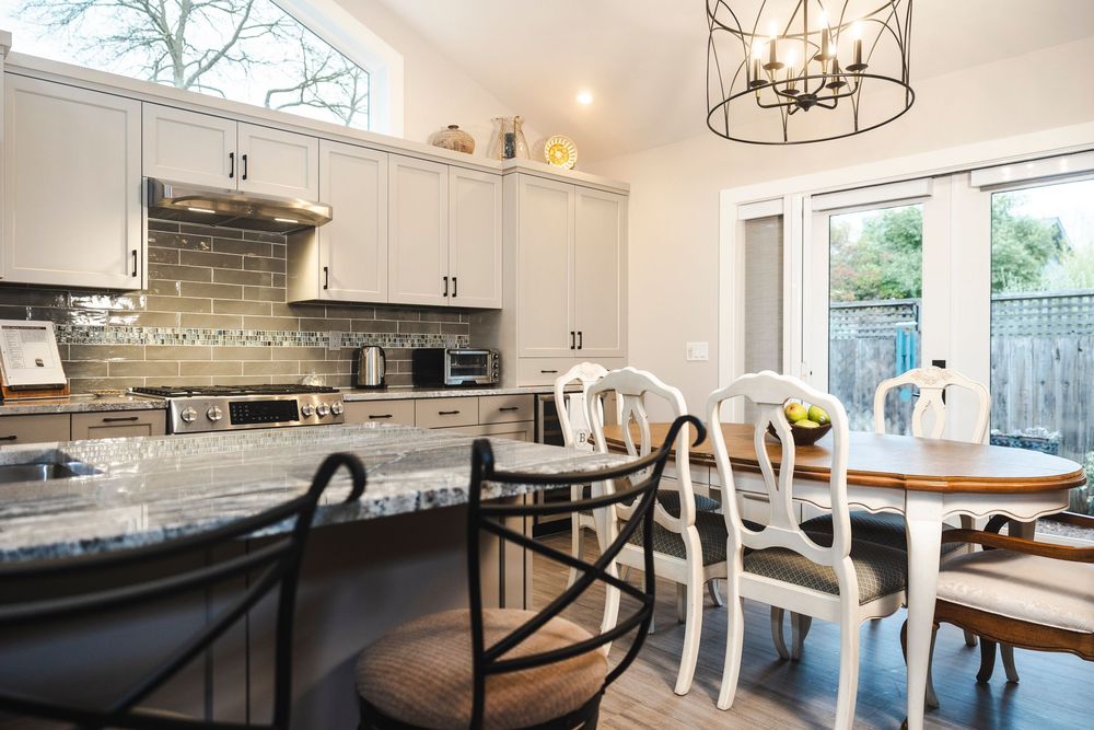 Modern white kitchen interior with pendant lighting, quartz countertops, and sleek cabinetry in an open concept design.