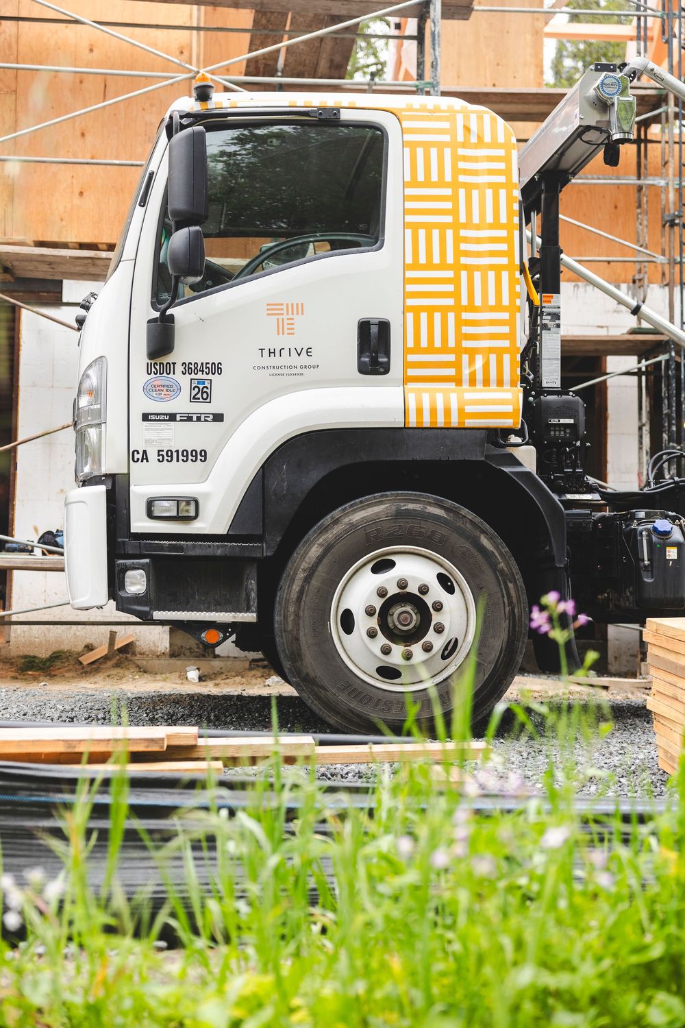 White commercial trucks parked in a row with yellow geometric patterns visible in the background.