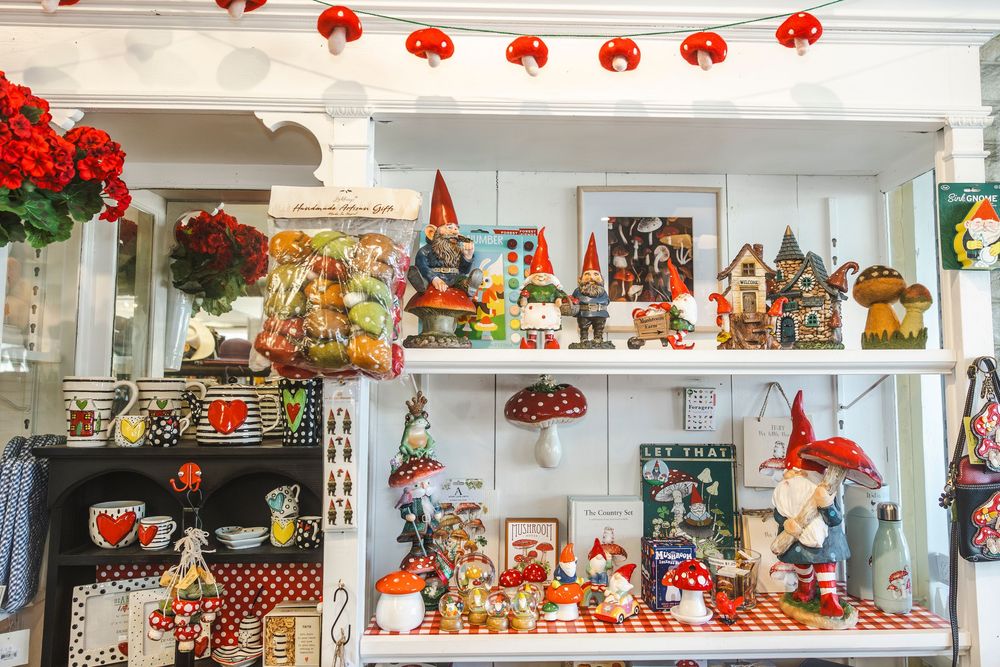 A collection of vintage Halloween decorations and collectibles displayed on white shelves with orange and black accents.