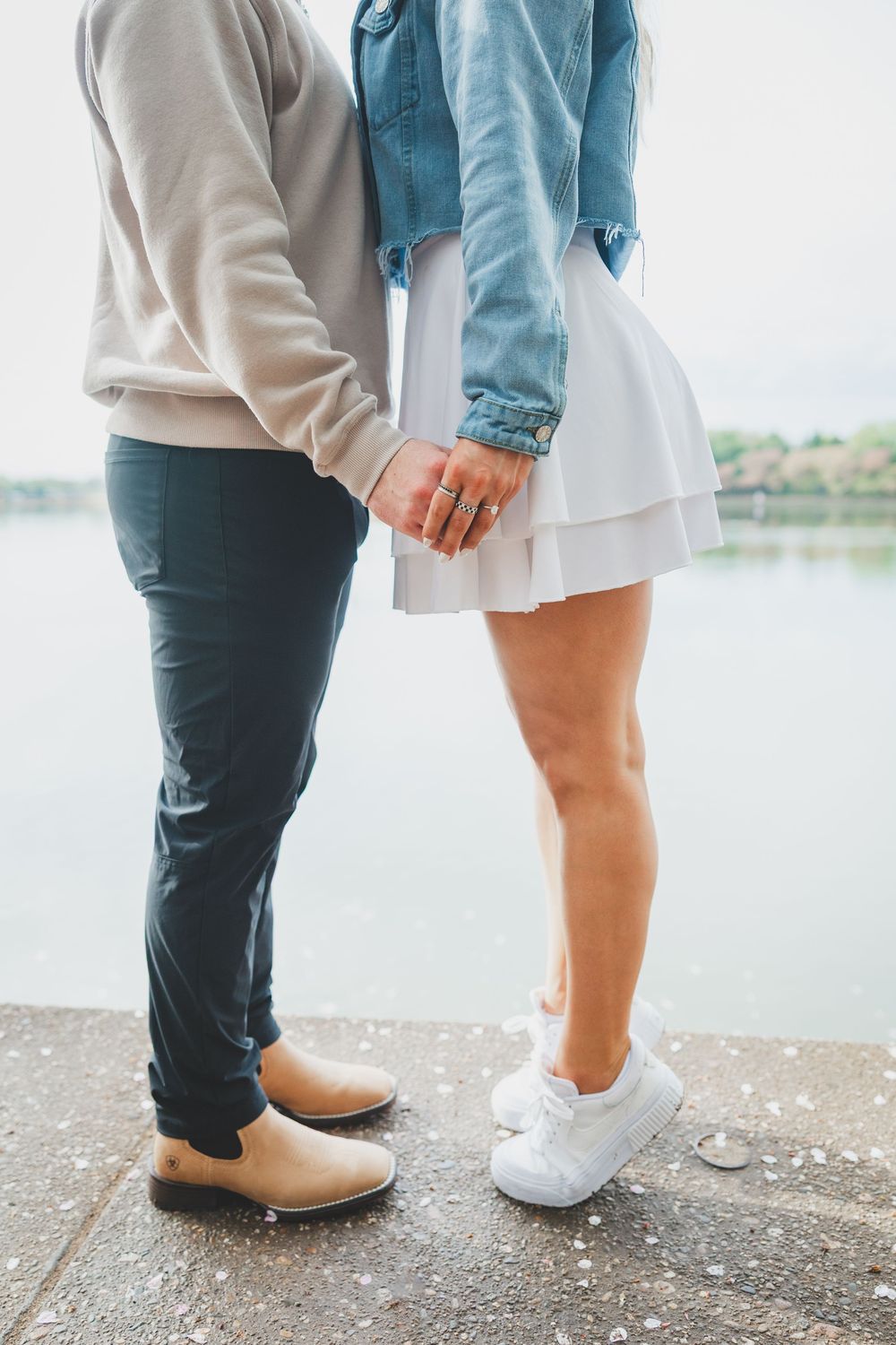 Close-up view of couple's feet wearing casual shoes standing together on a the tidal basin