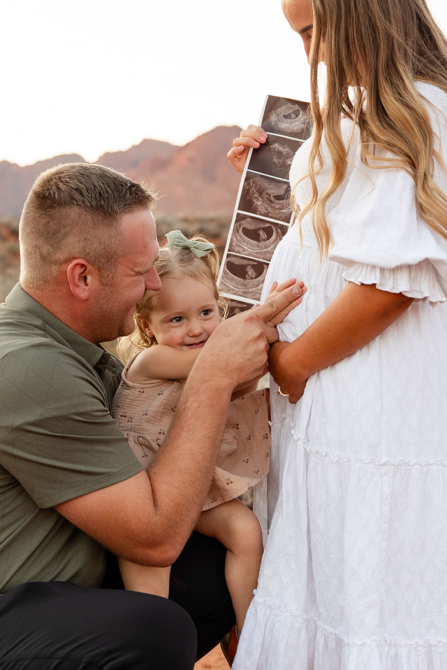 dad and 2 year old stroking moms belling looking at her belly
