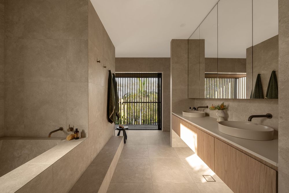 Minimalist concrete interior with angular walls and natural light streaming through windows creating dramatic shadows.