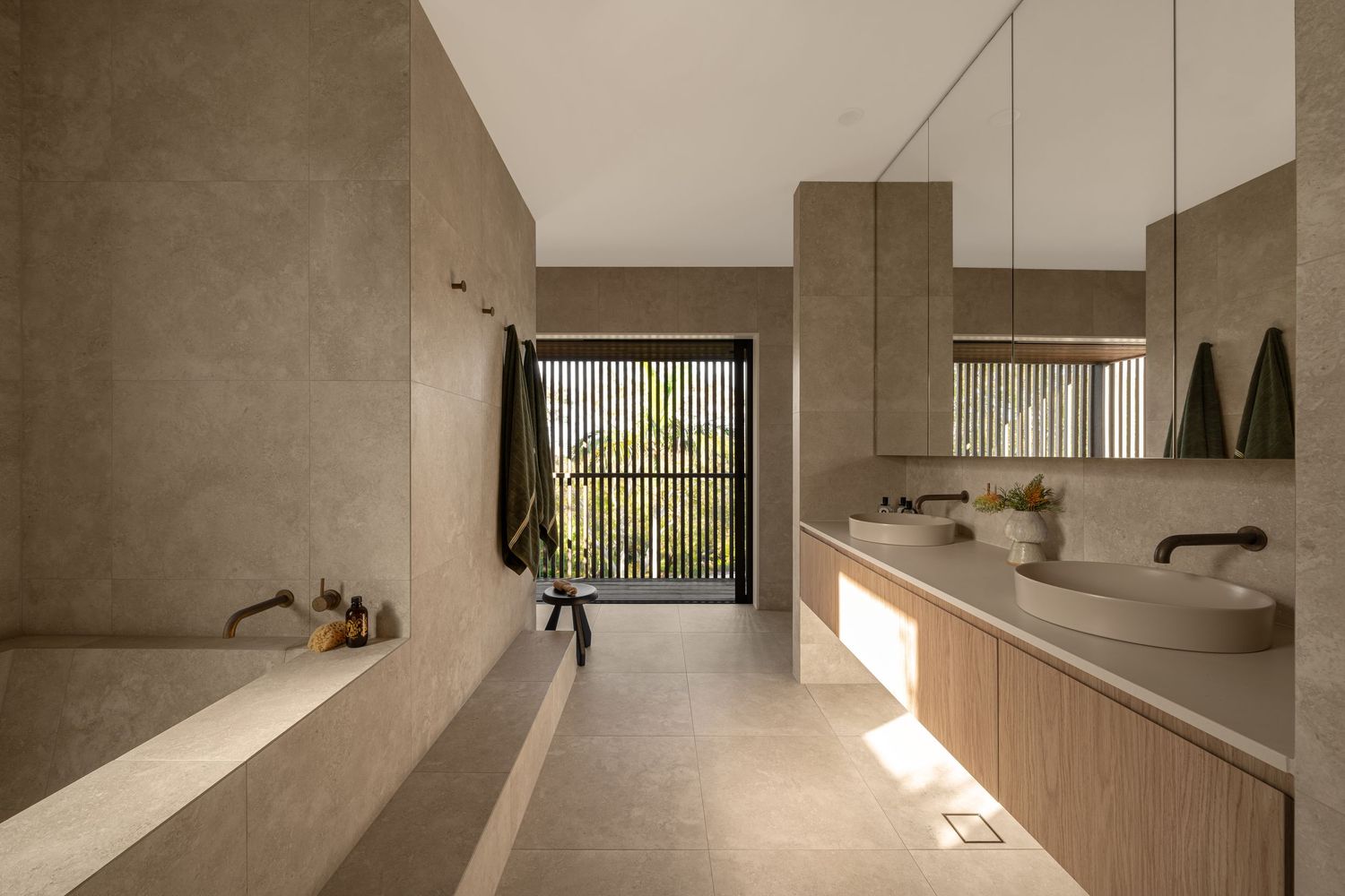 Minimalist concrete interior with angular walls and natural light streaming through windows creating dramatic shadows.