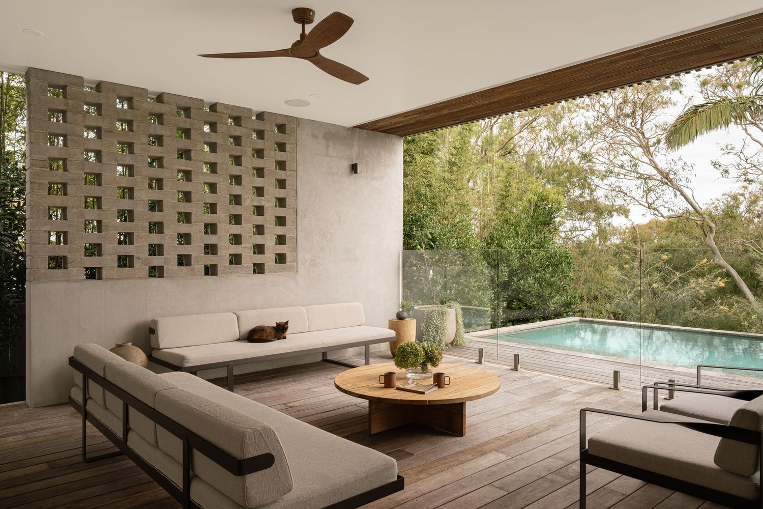 Luxurious covered patio with L-shaped sofa and pool view showcasing modern architectural design elements.