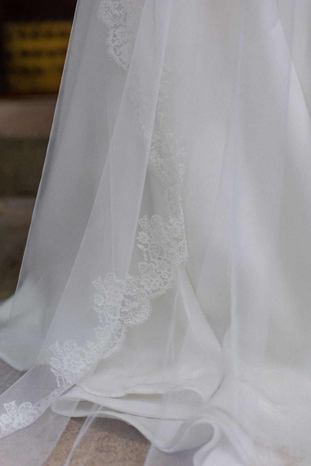 Close-up details of delicate white lace and tulle fabric from a wedding dress.