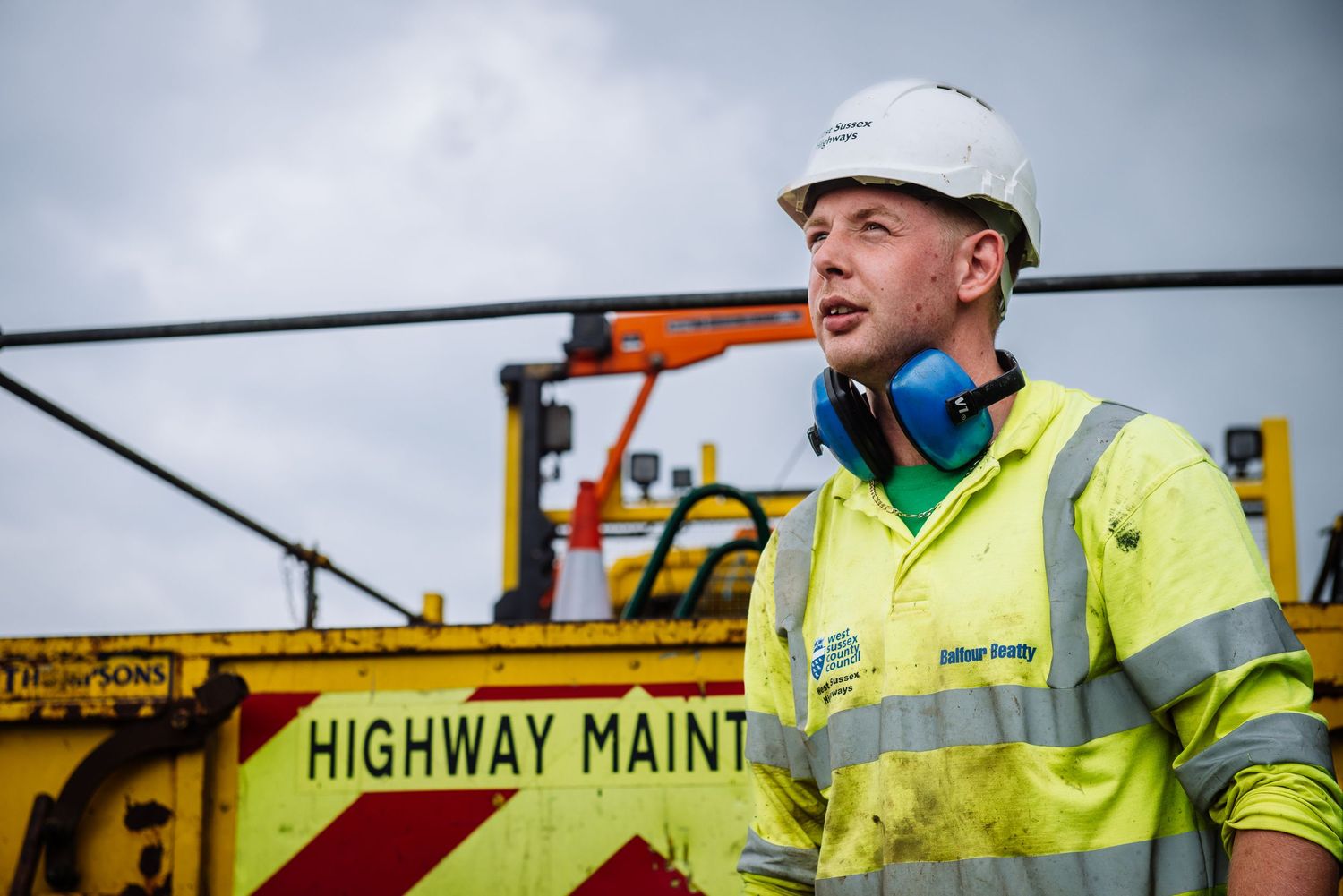 Highway maintenance workers in high visibility vests working on a construction site.