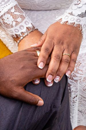 Close-up series of hands with French manicured nails against a white lace and dark fabric background.