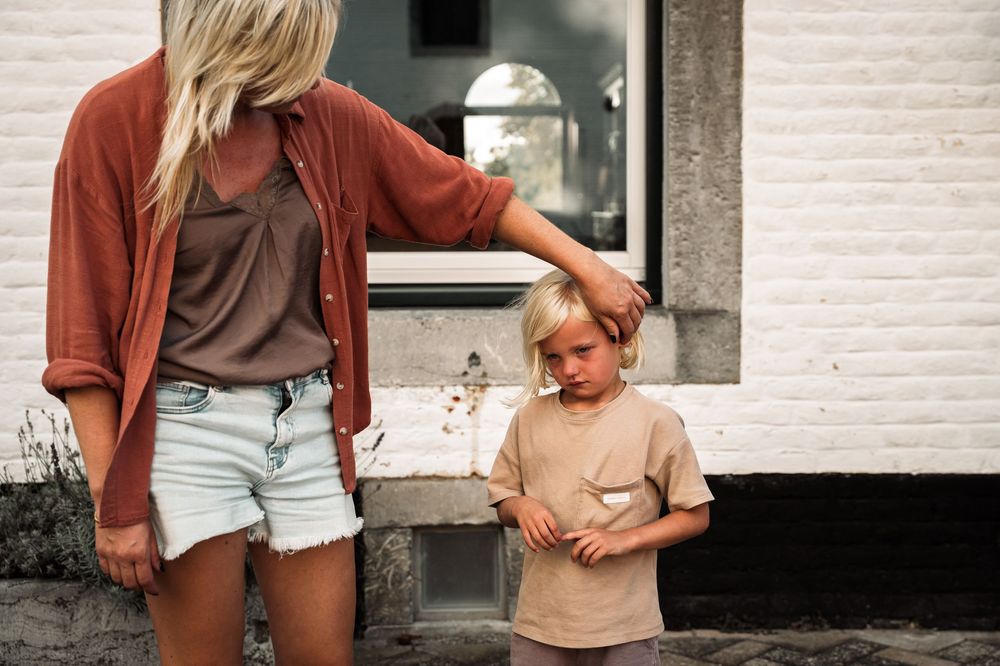 Casual outdoor scene with light summer clothing against a white building backdrop.