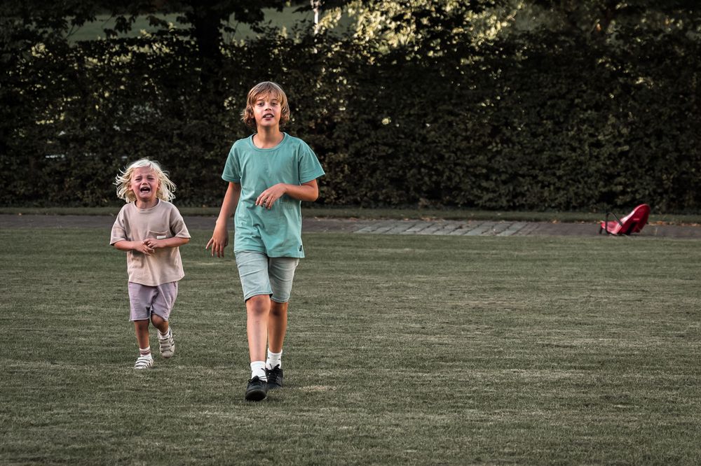 People walking across a lush green lawn in summer.