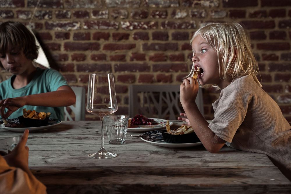 People gathered around a dining table with brick wall backdrop.