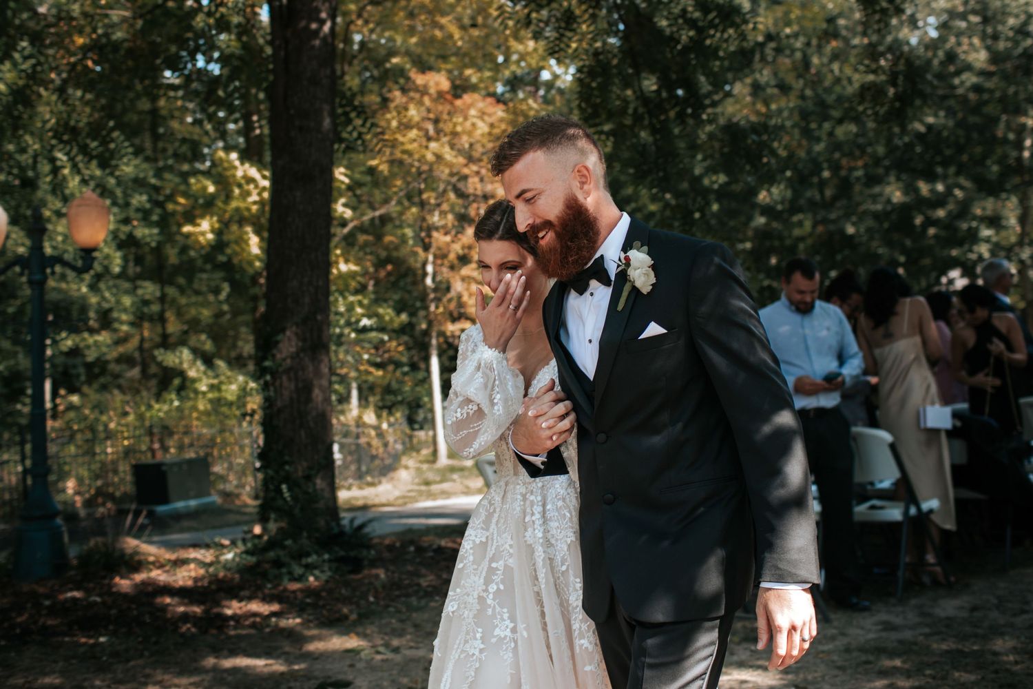 An emotional outdoor wedding ceremony moment captured in a natural wooded setting.