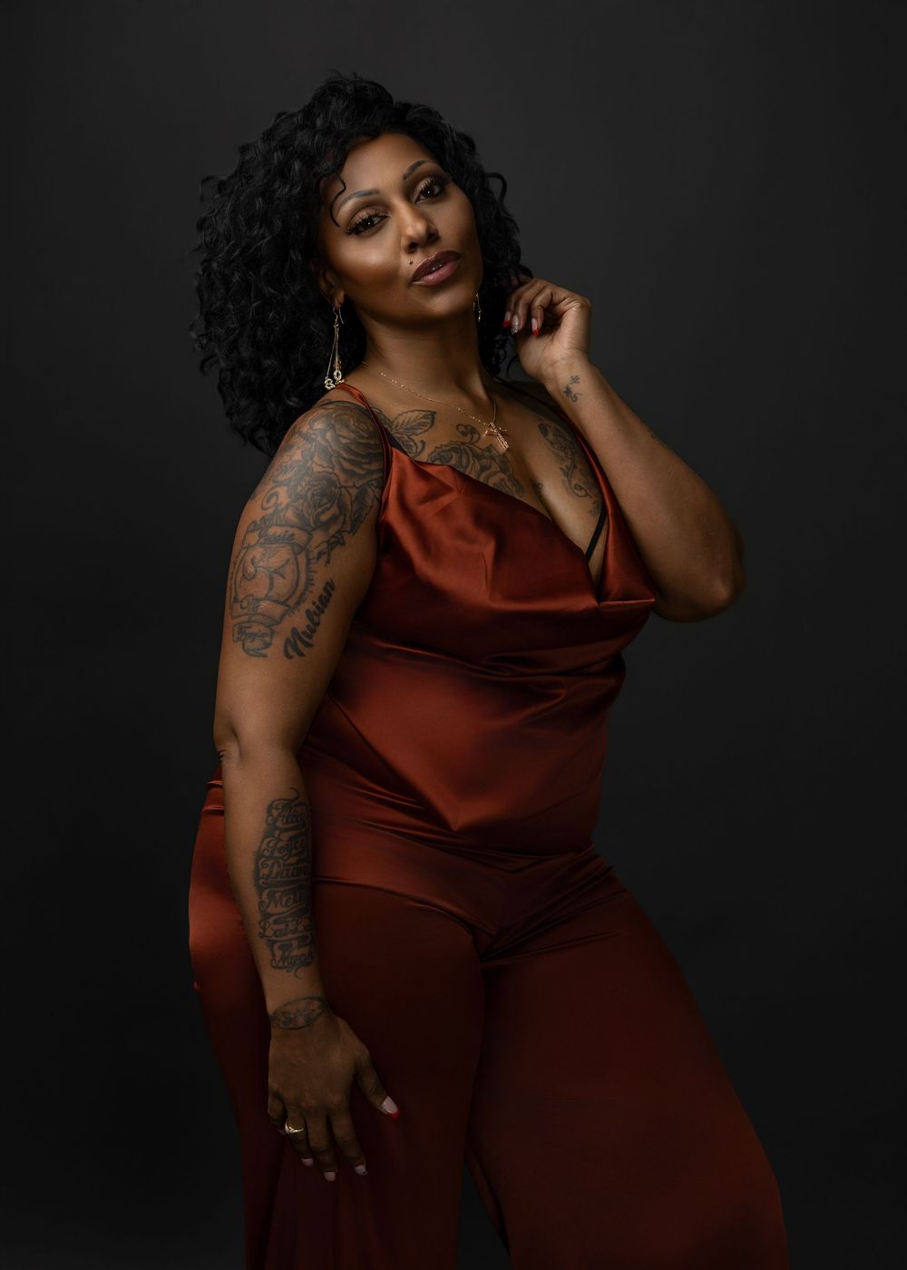 A figure in a burgundy velvet dress poses elegantly against a dark background in a series of artistic portraits.