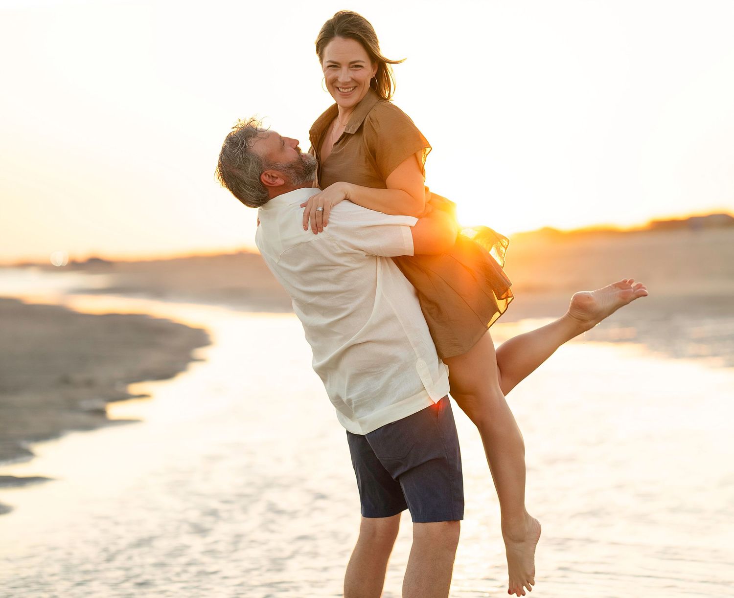 Man picking up woman on beach during Matagorda Photography Session on Matagorda Beach.