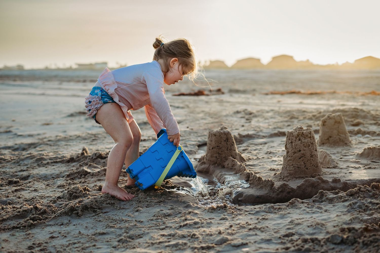 Young child building a sandcastle at Matagorda Beach during a Matagorda Vacation Sunset Beach Photography Session.