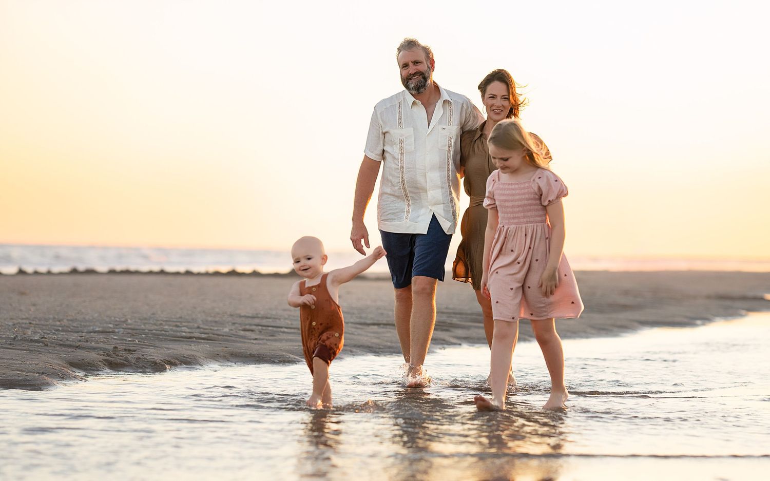 Family walking down the beach in the water at Matagorda Beach during a Matagorda Vacation Sunset Beach Photography Session.