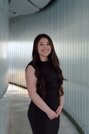Graduate poses for a professional headshot in the hallway at the University of San Francisco. Bay Area Graduation Photographer.