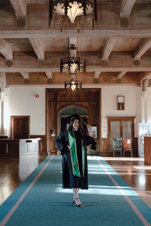 Graduate stands in the library during her grad photoshoot at the University of San Francisco. By Bay Area Graduation Photographer.