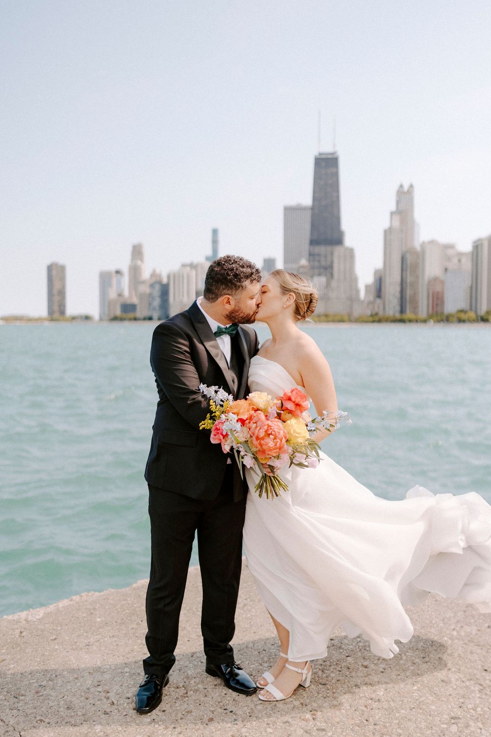 A romantic wedding photoshoot on Lake Michigan's shore with Chicago's iconic skyline in the background.