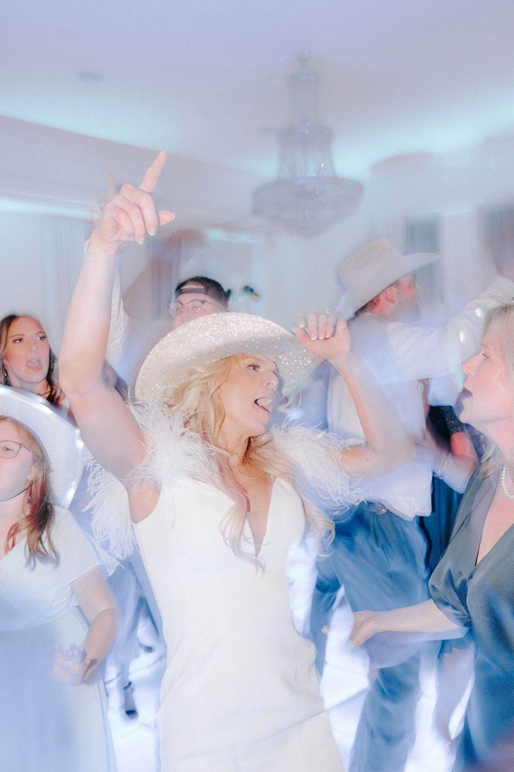 Multiple exposure photograph showing ethereal dance movement sequence in soft blue and white tones.