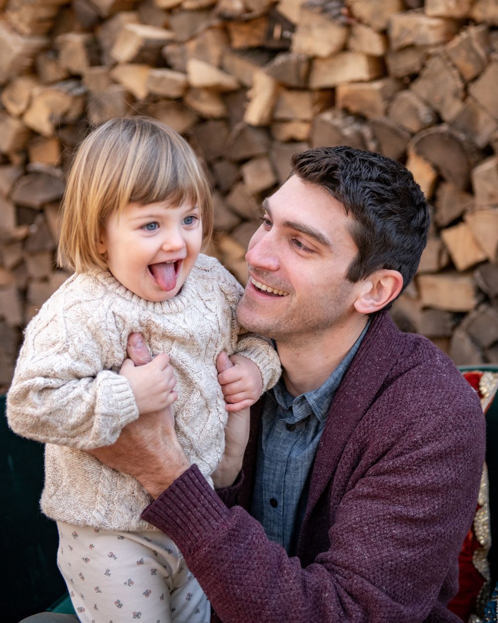 A joyful moment shared between two people against a stacked wood background.