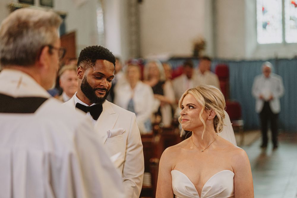 Wedding ceremony guests sharing joyful moments during an indoor celebration.