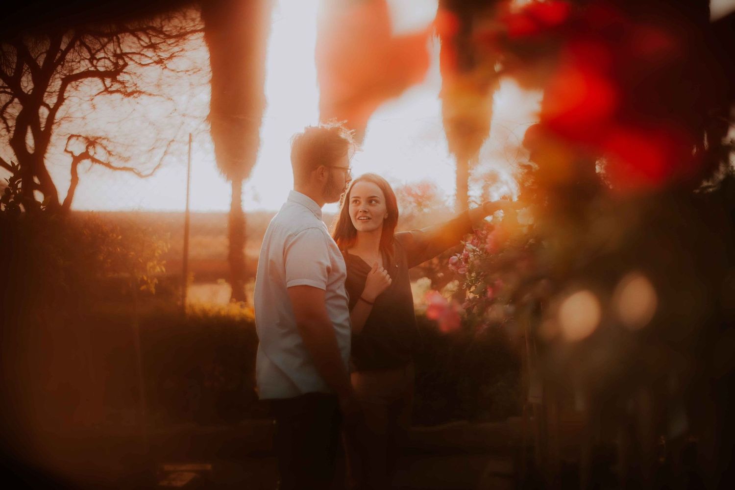 A couple enjoying a romantic moment in warm sunset lighting with bokeh effects.
