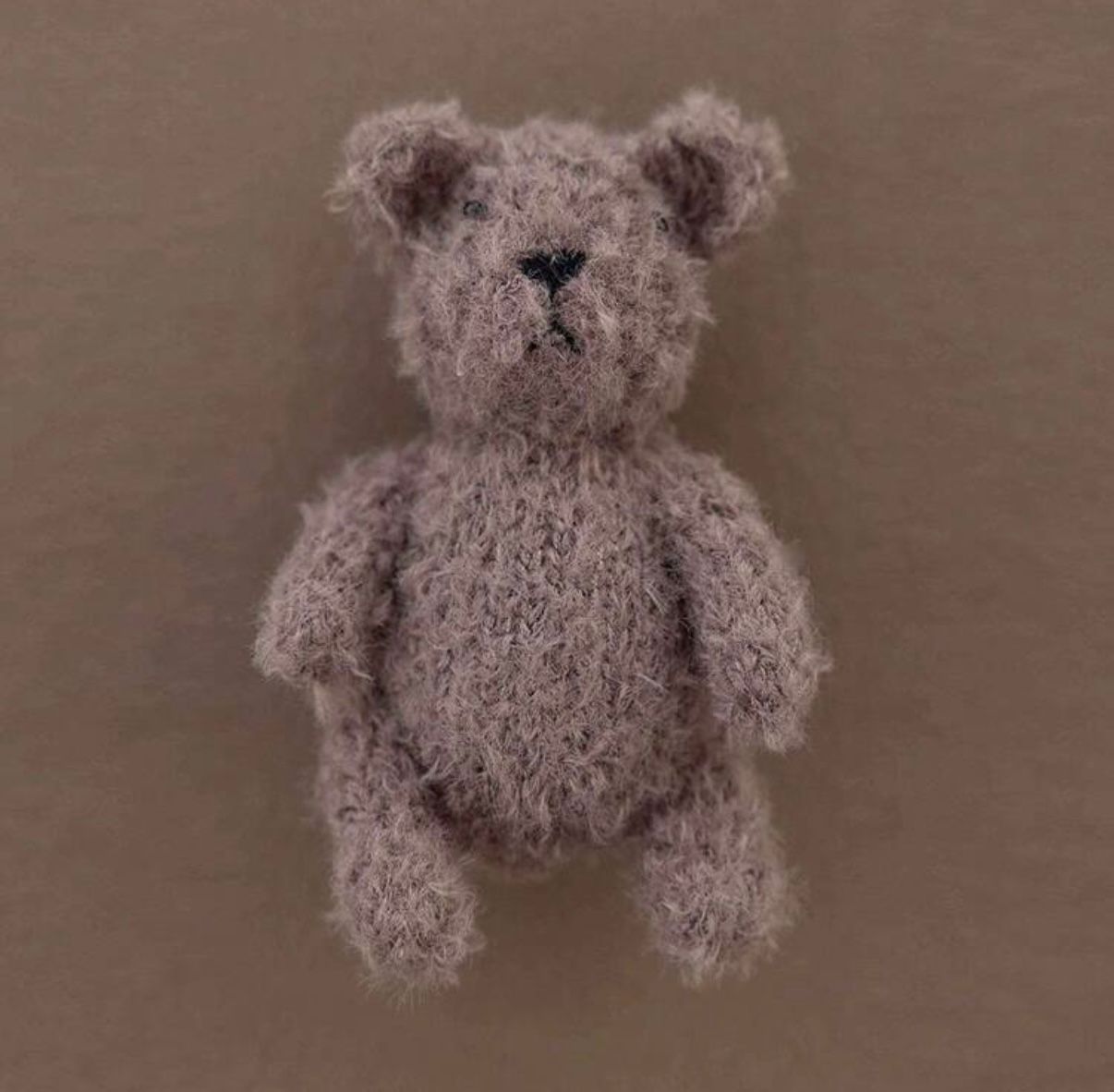 A handmade brown teddy bear shown in different angles on a dark brown surface.