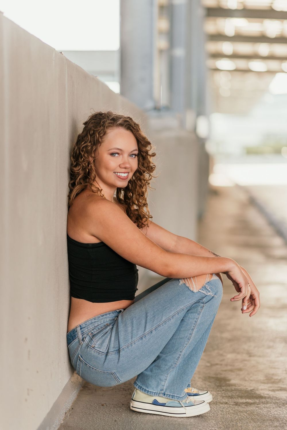 A senior portrait outside in a parking garage in Washington D.C. featuring morning golden light.