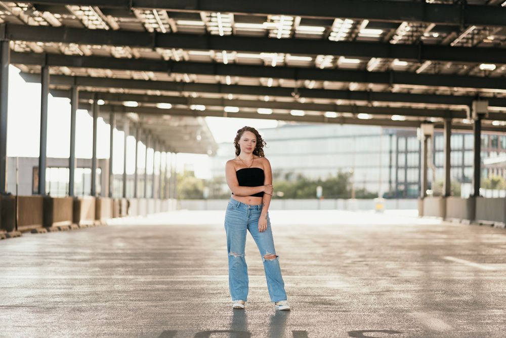 A senior portrait outside in a parking garage in Washington D.C. featuring morning golden light.