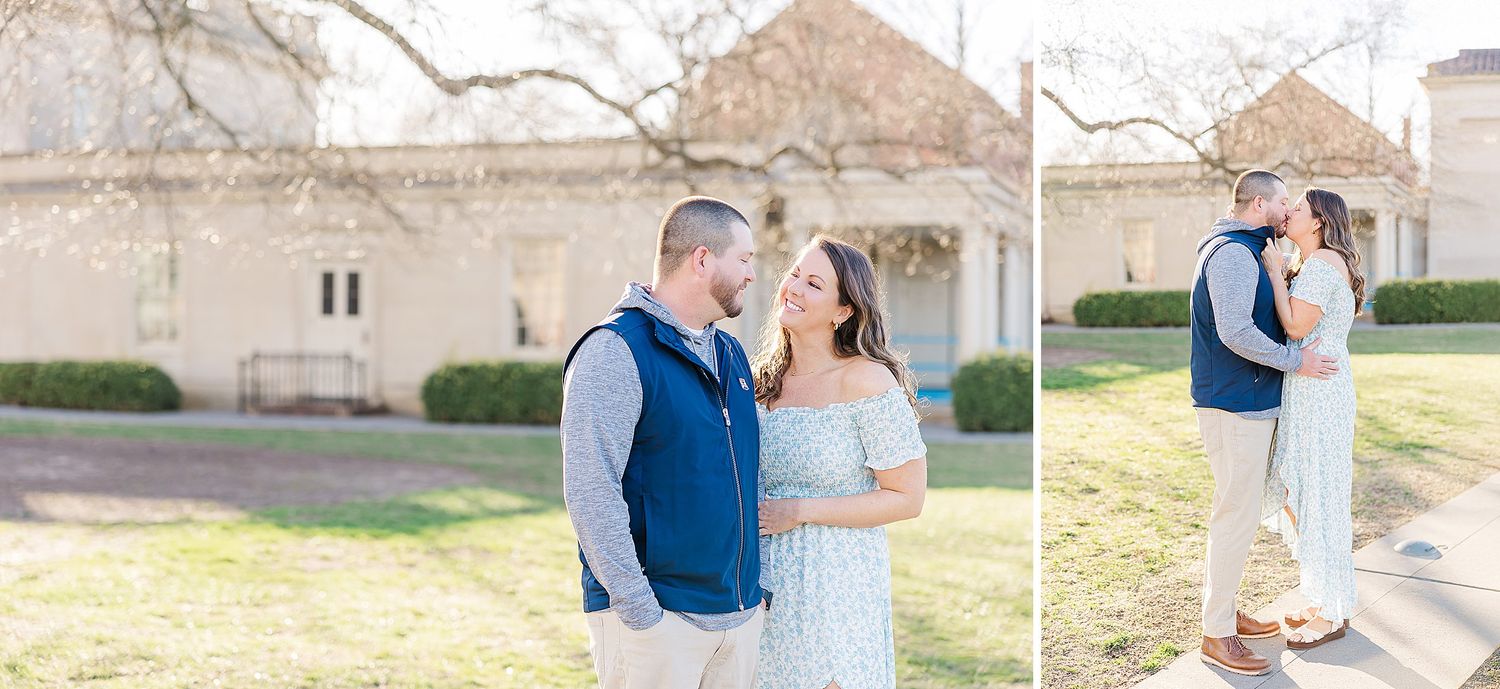 A couple in formal attire shares a romantic moment outdoors at their countryside wedding celebration.