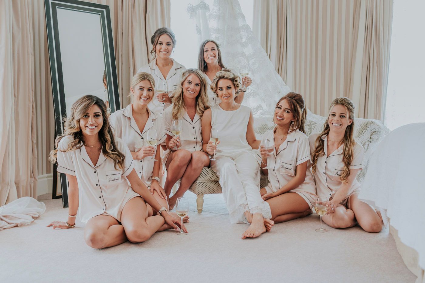 Group in matching silk robes gathered together for pre-wedding celebrations.
