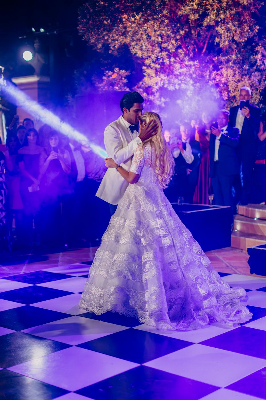 Romantic wedding dance scene on a black and white checkerboard floor with purple mood lighting and cherry blossoms overhead.