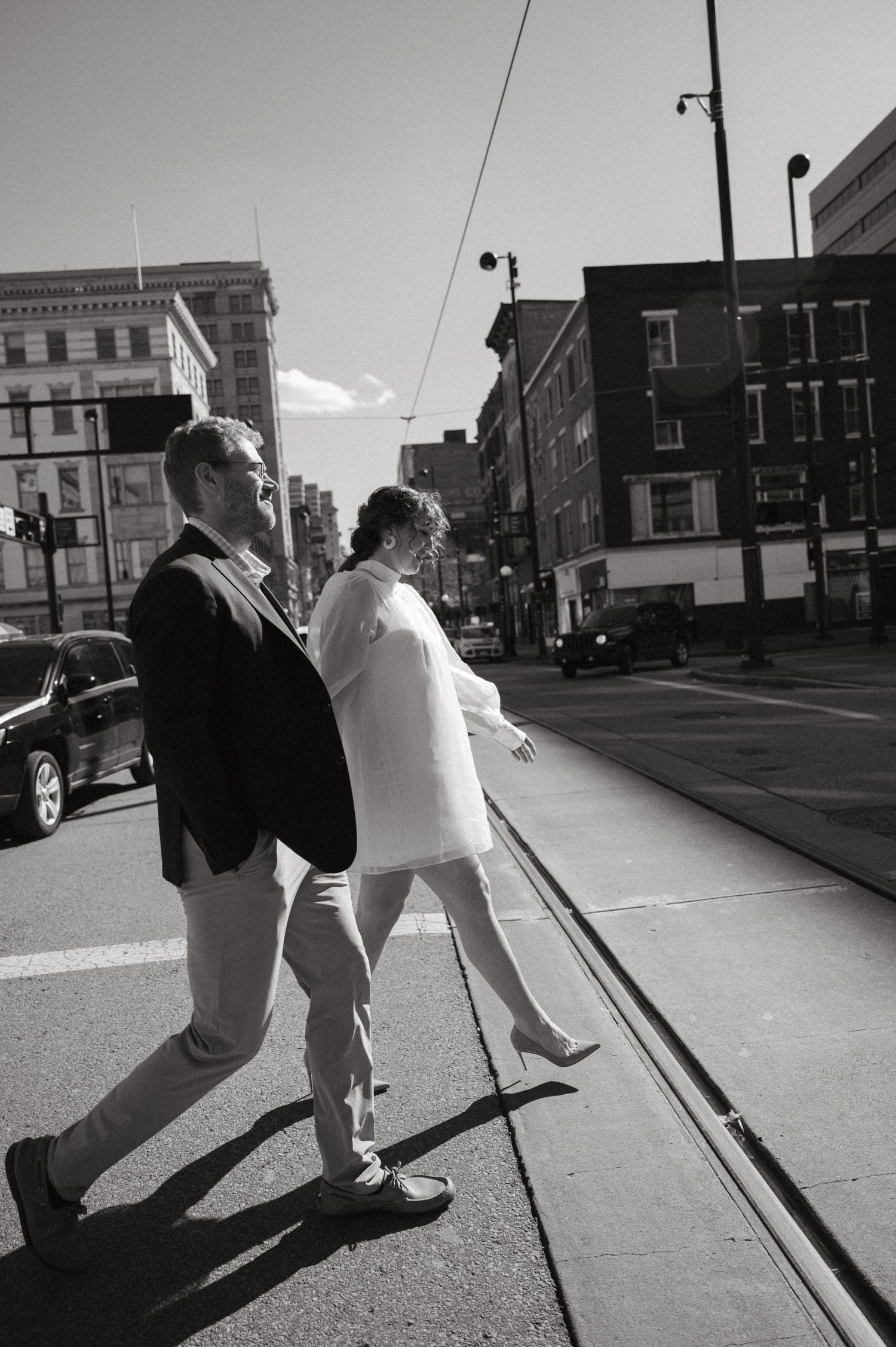 Urban black and white street scene with couple walking along city sidewalk.