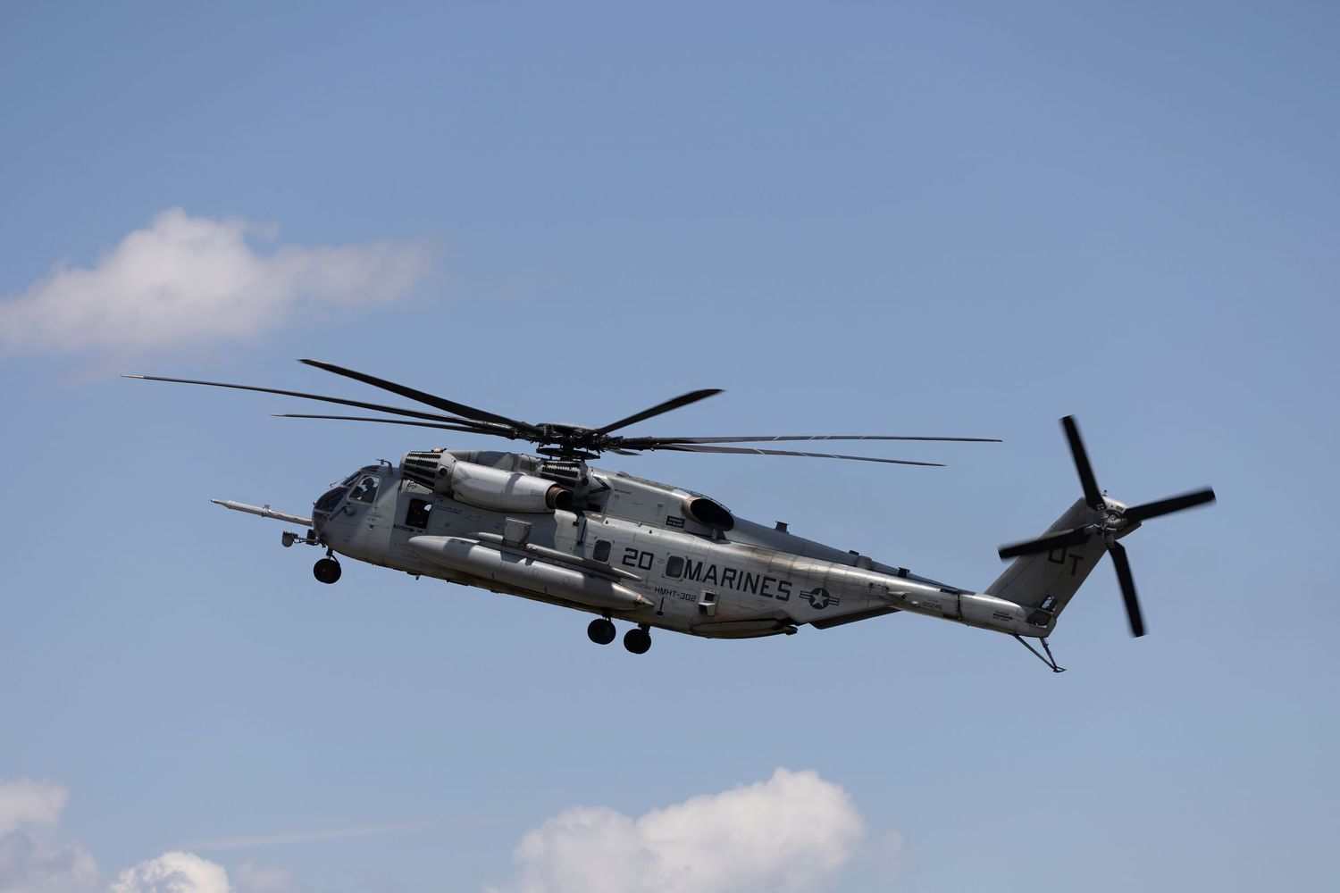 CH-53E Super Stallion military helicopter flying against clear blue sky during demonstration.