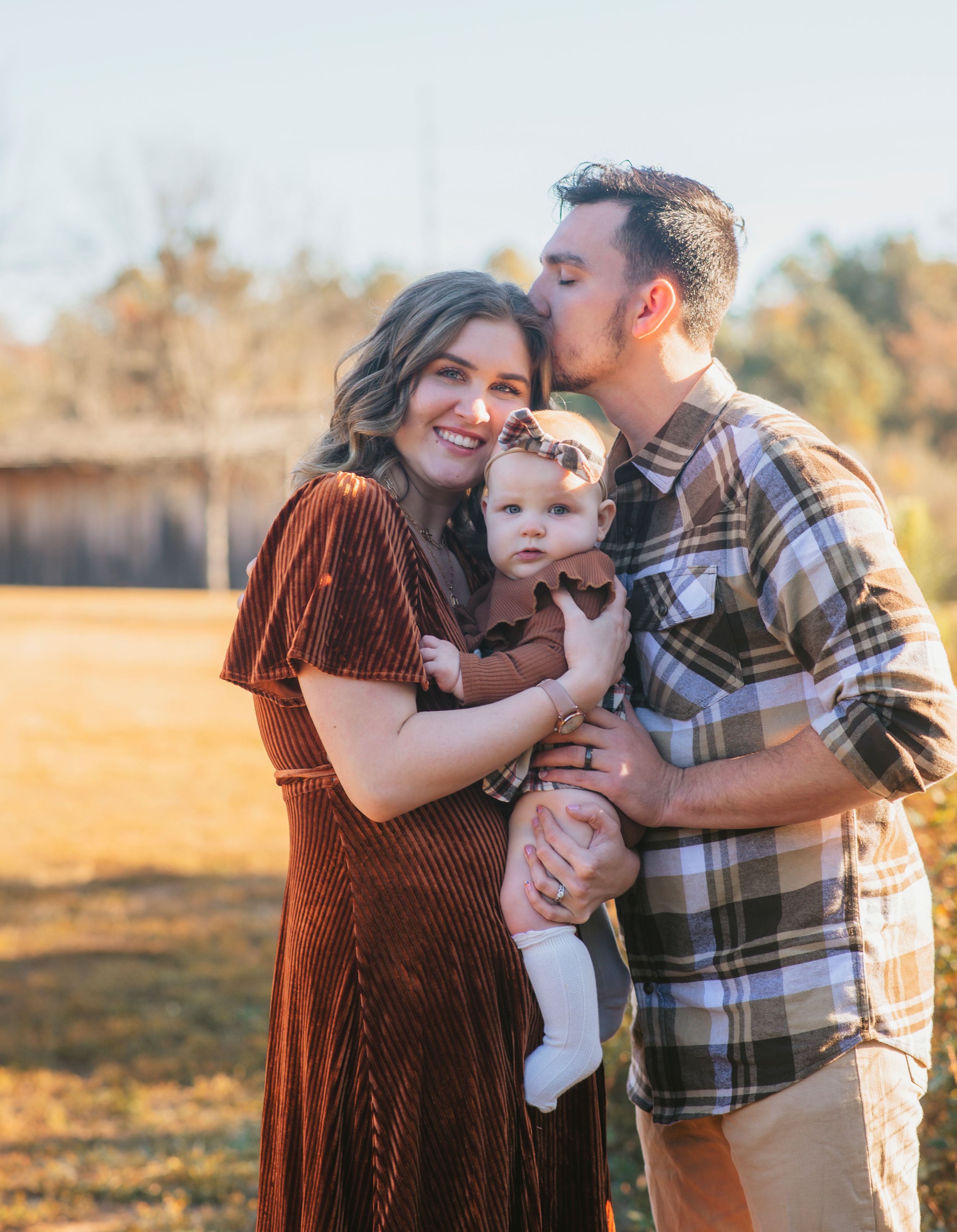 A sweet family portrait in autumn with coordinated outfits during golden hour.
