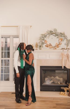 A couple shares an intimate dance moment in an elegant white room with a fireplace and decorative accents.