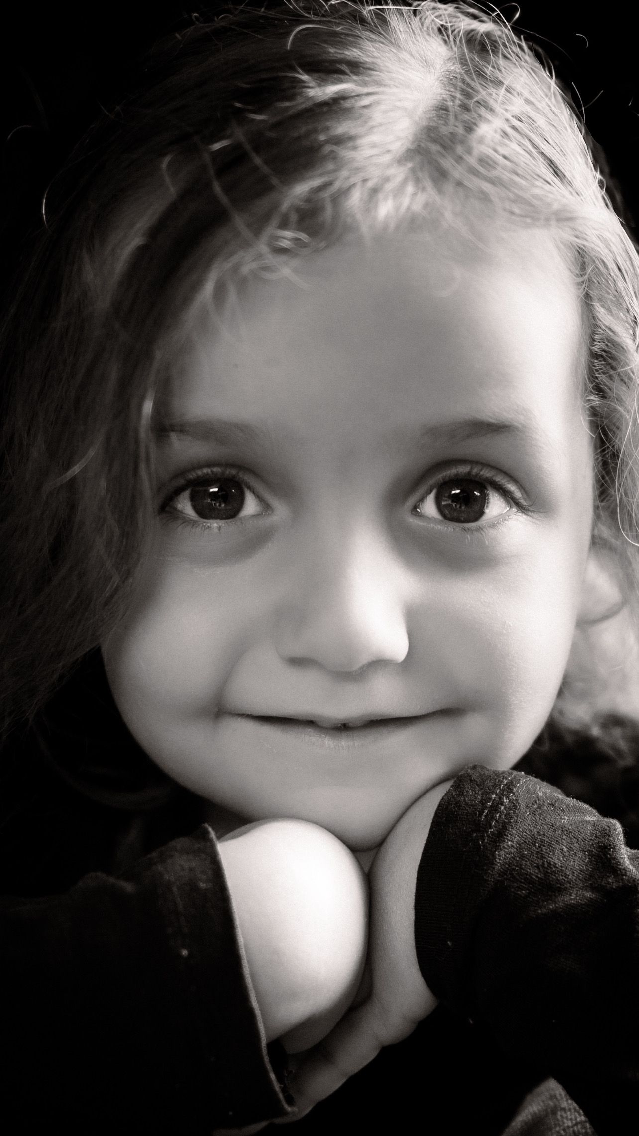Black and white portrait showcasing bright eyes and gentle smile.