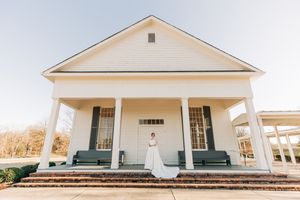 Elegant white church building with a prominent front porch, symmetrical columns and classic Greek Revival architecture.
