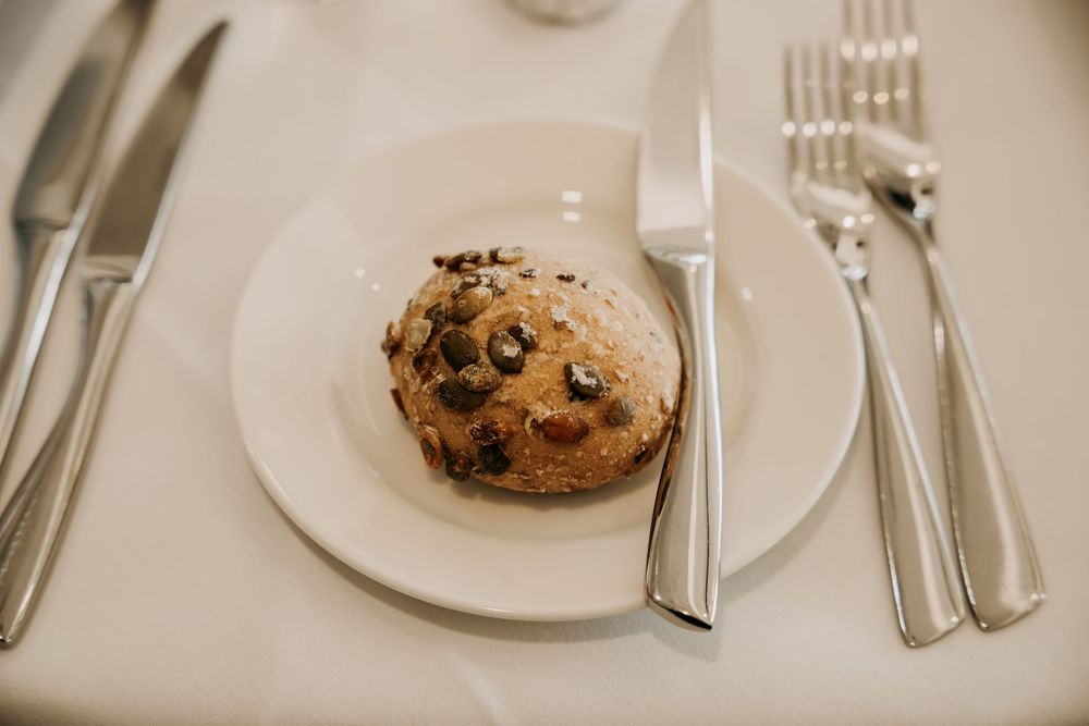 Chocolate chip cookies on white plates with silverware arranged in a restaurant setting.