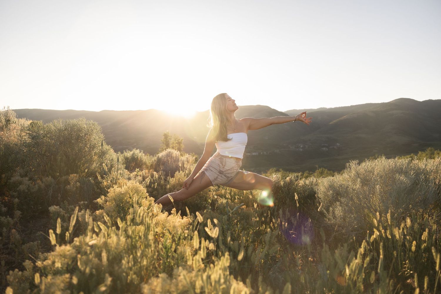 Yoga portrait in warm lighting with a mountain background.