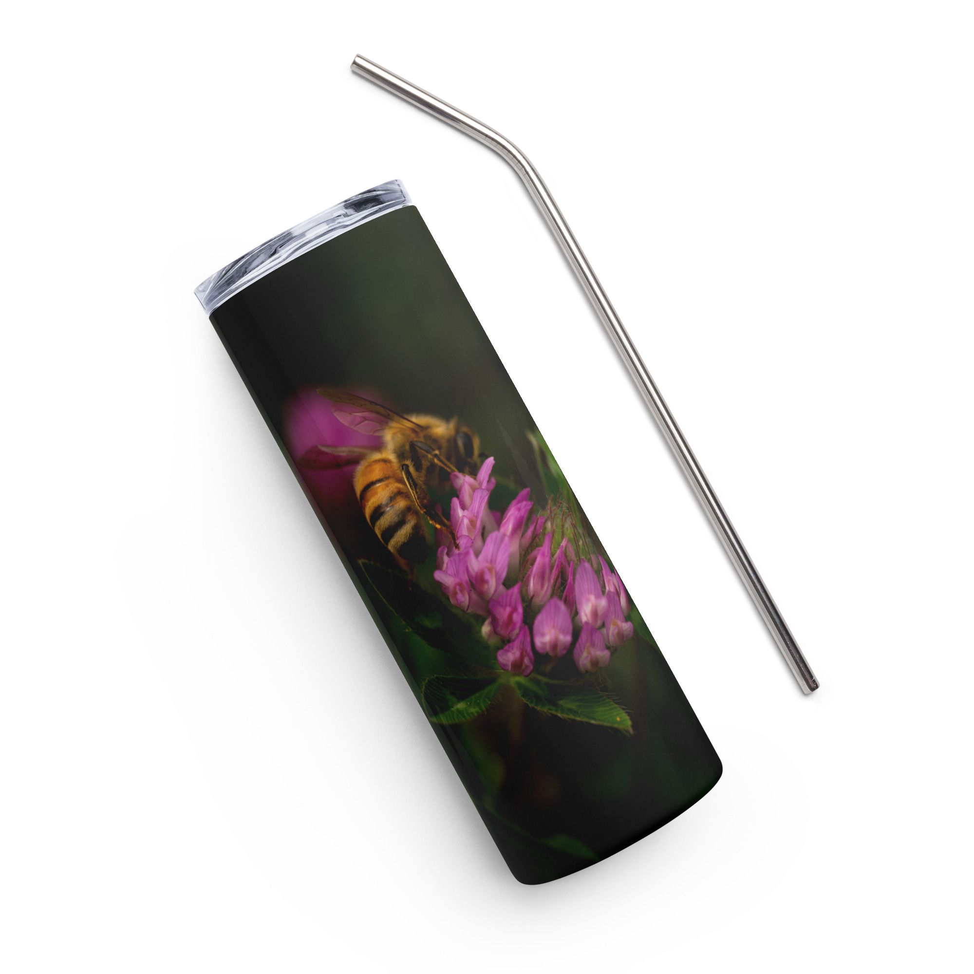 A honey bee hovers near vibrant pink astilbe flowers against a dark background in a macro photograph.