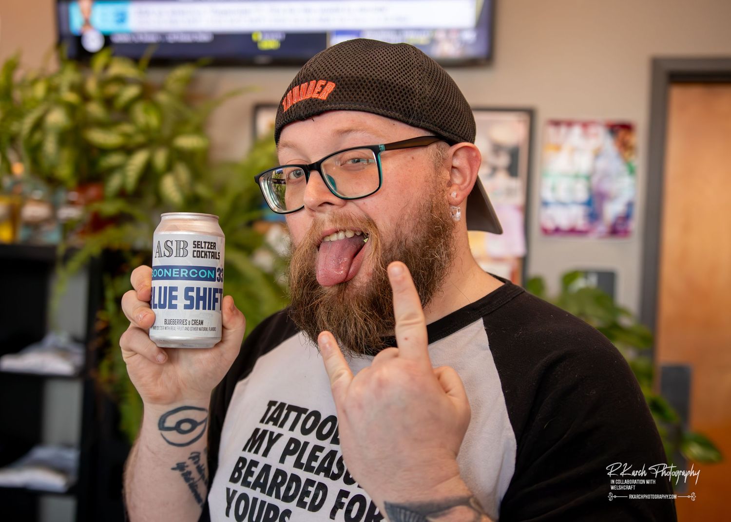 Bearded person in glasses and baseball cap holds up Blue Snow shaving soap while making excited expression.