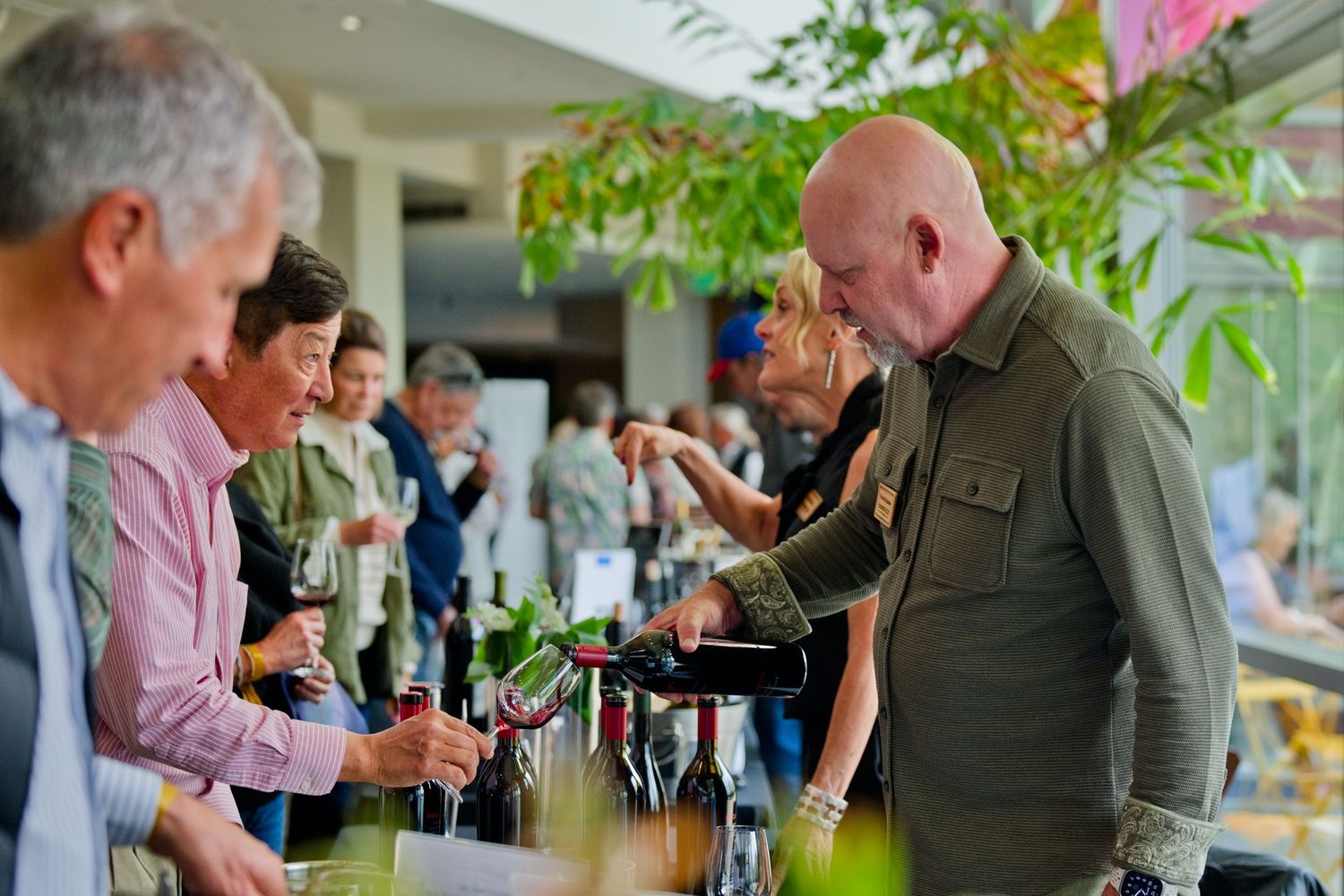 Guests gather around a tasting table at CIA Copia in Napa Valley, sampling and discussing a curated selection of fine wines.