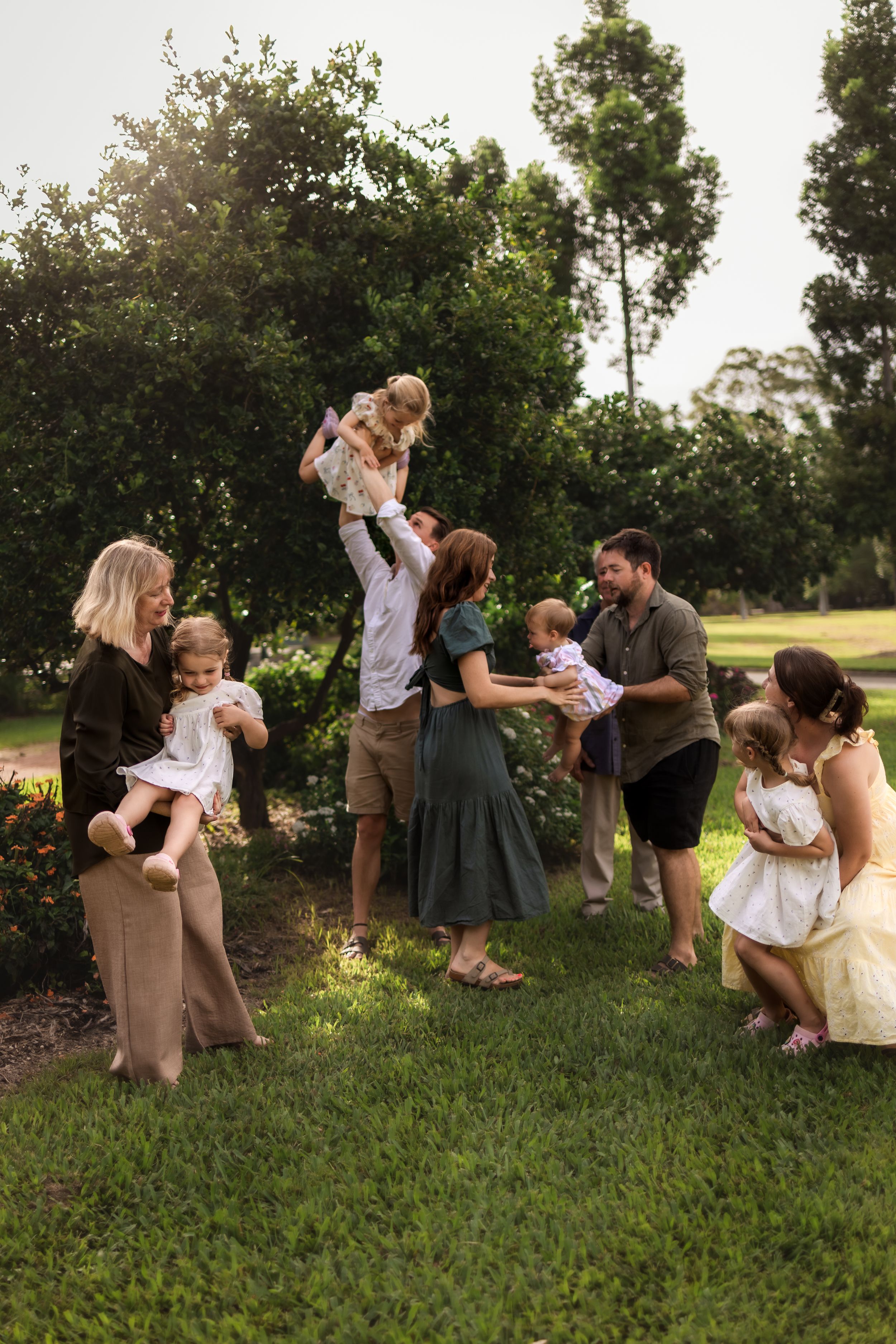 A series of candid family photos showing joyful interactions and playful moments on a grassy hill during golden hour.