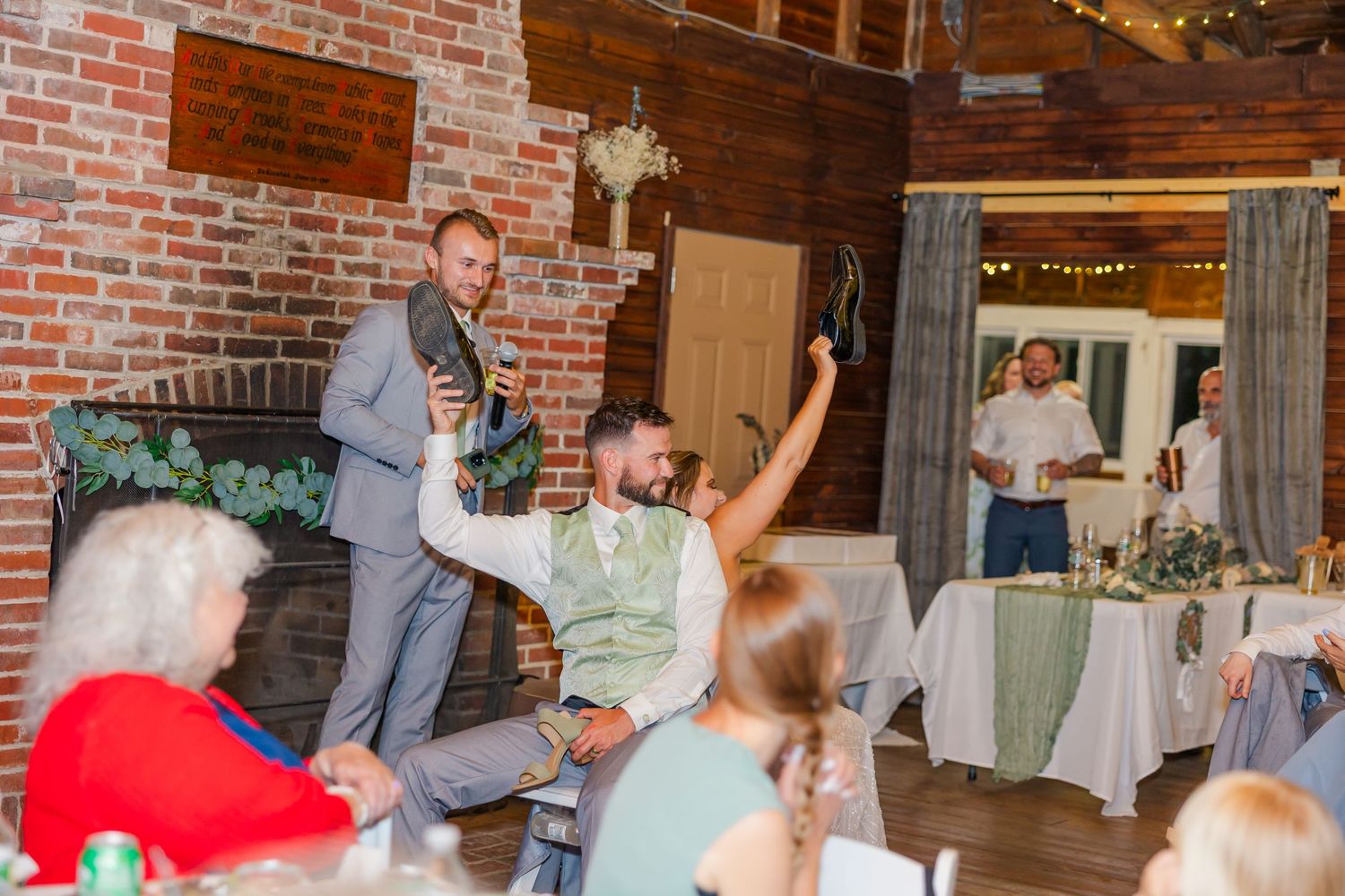 Celebratory scene inside a rustic brick venue with people gathered at tables during an event celebration.