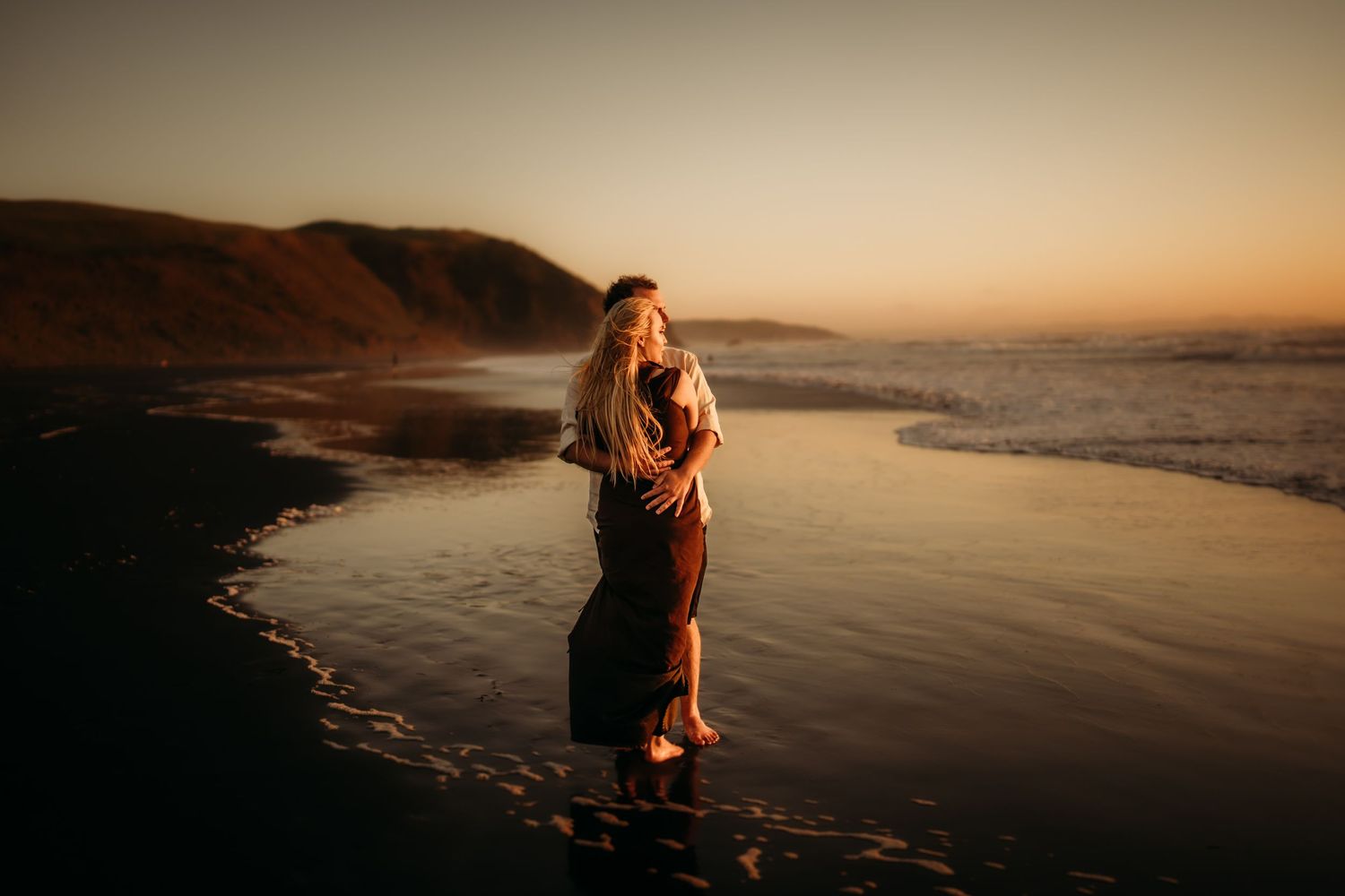 engagement-photo-at-sunset-newzealand-beach-couple-hugging