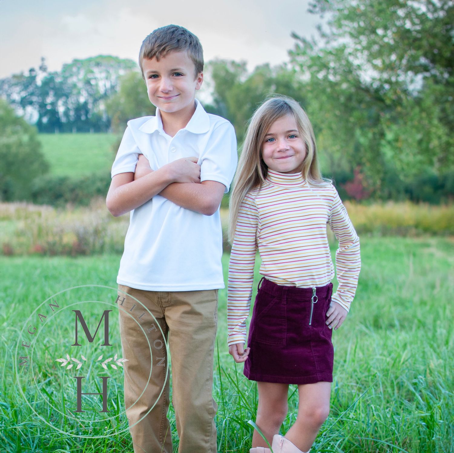 Boy and girl standing together in field fall photo