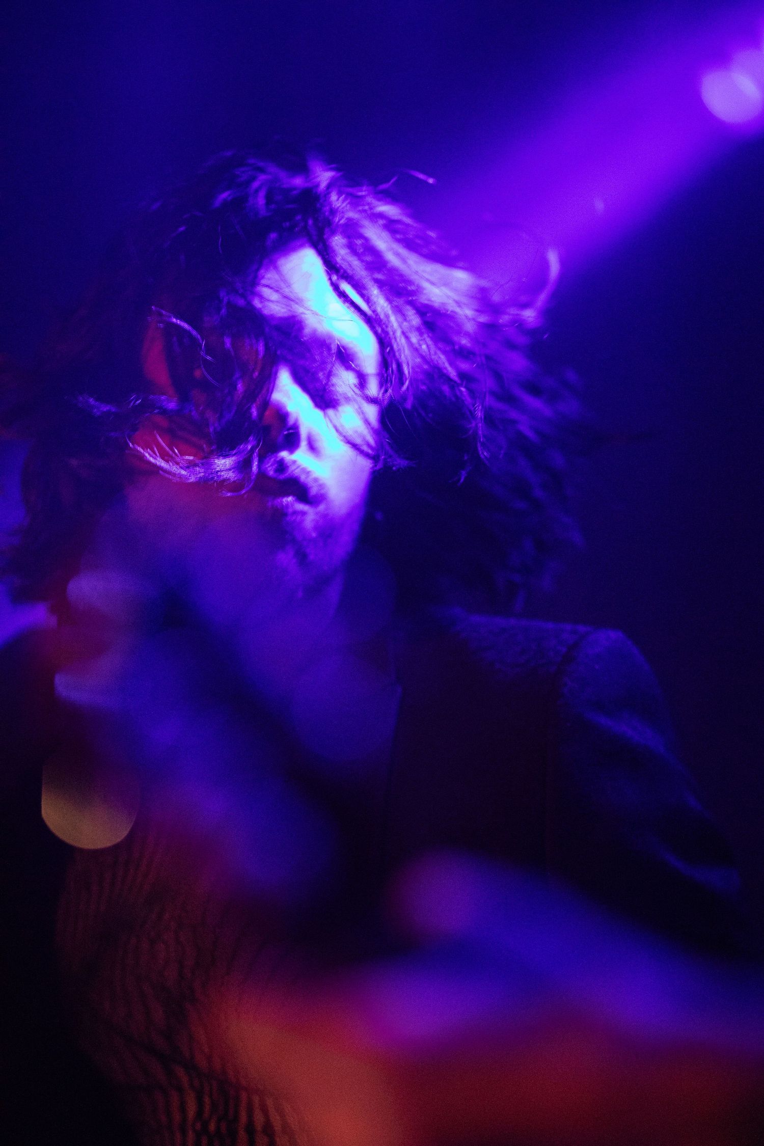 Concert performance bathed in dramatic purple and blue lighting effects.