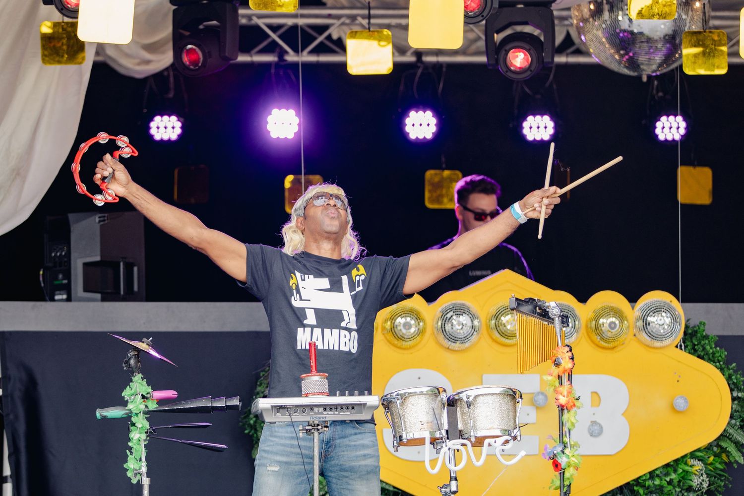 Professional DJ equipment setup with yellow accents and purple lighting on a dark stage.